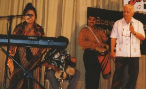 An elderly singer  delights the crowd together with the drummers